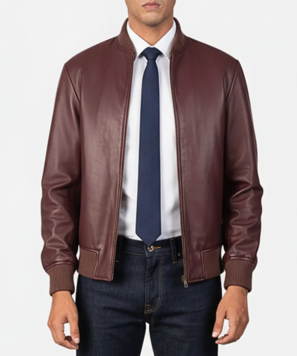 Man wearing a mens burgundy leather jacket front view showing zip closure and varsity collar in natural daylight.