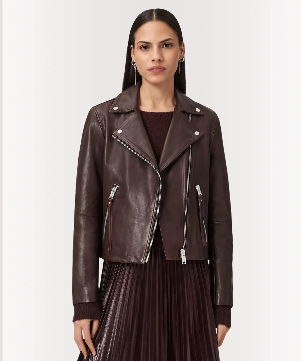 Woman wearing an oxblood leather biker jacket with zip details and slim fit style.