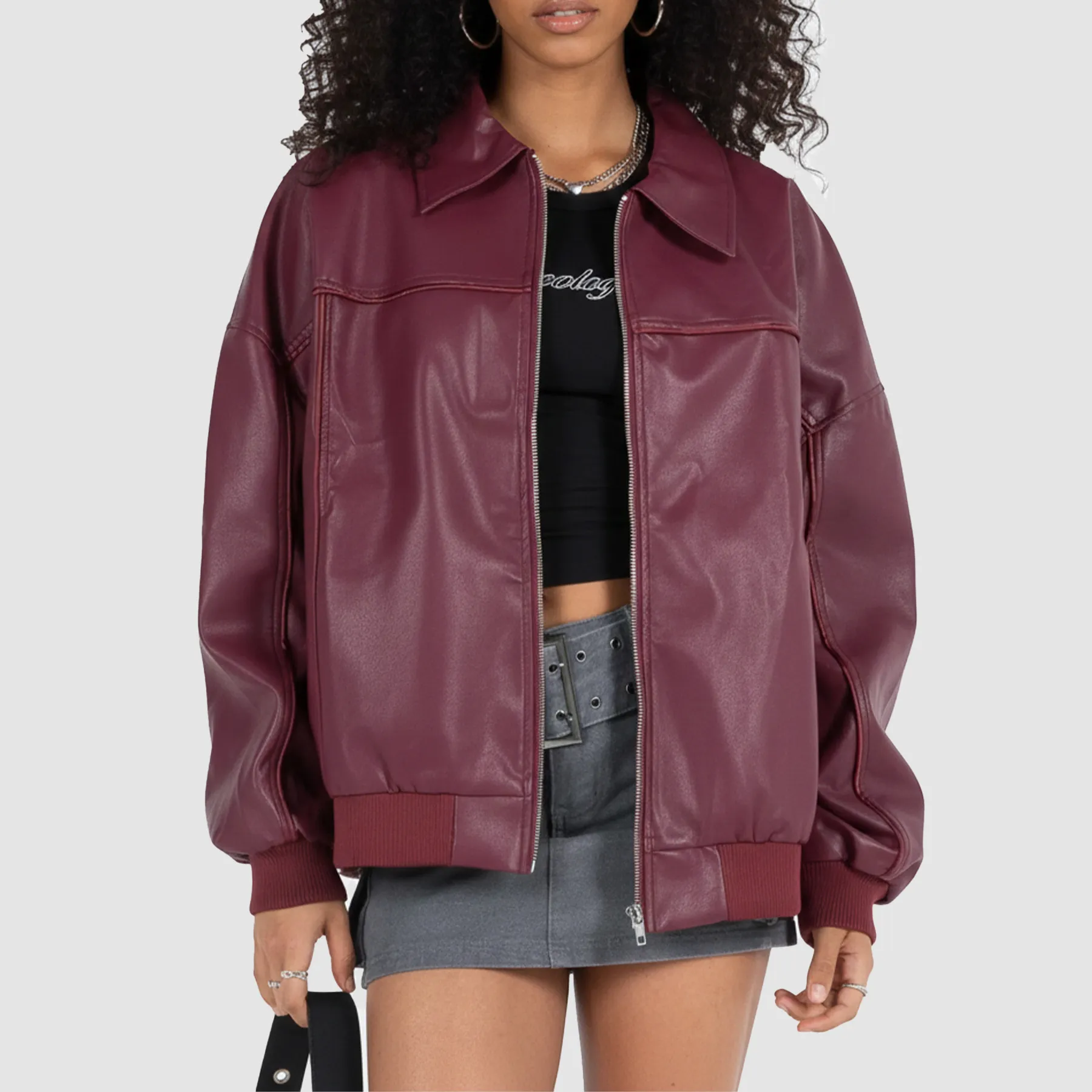 Woman wearing maroon leather jacket styled casually for everyday urban streetwear.