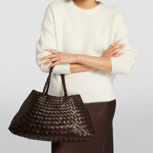 model wearing dark brown woven leather tote bag on her arm