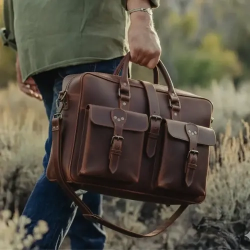 chestnut flight briefcase in the hands of a man walking in a field